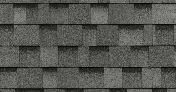 Close-up of gray asphalt roof shingles in a layered pattern.