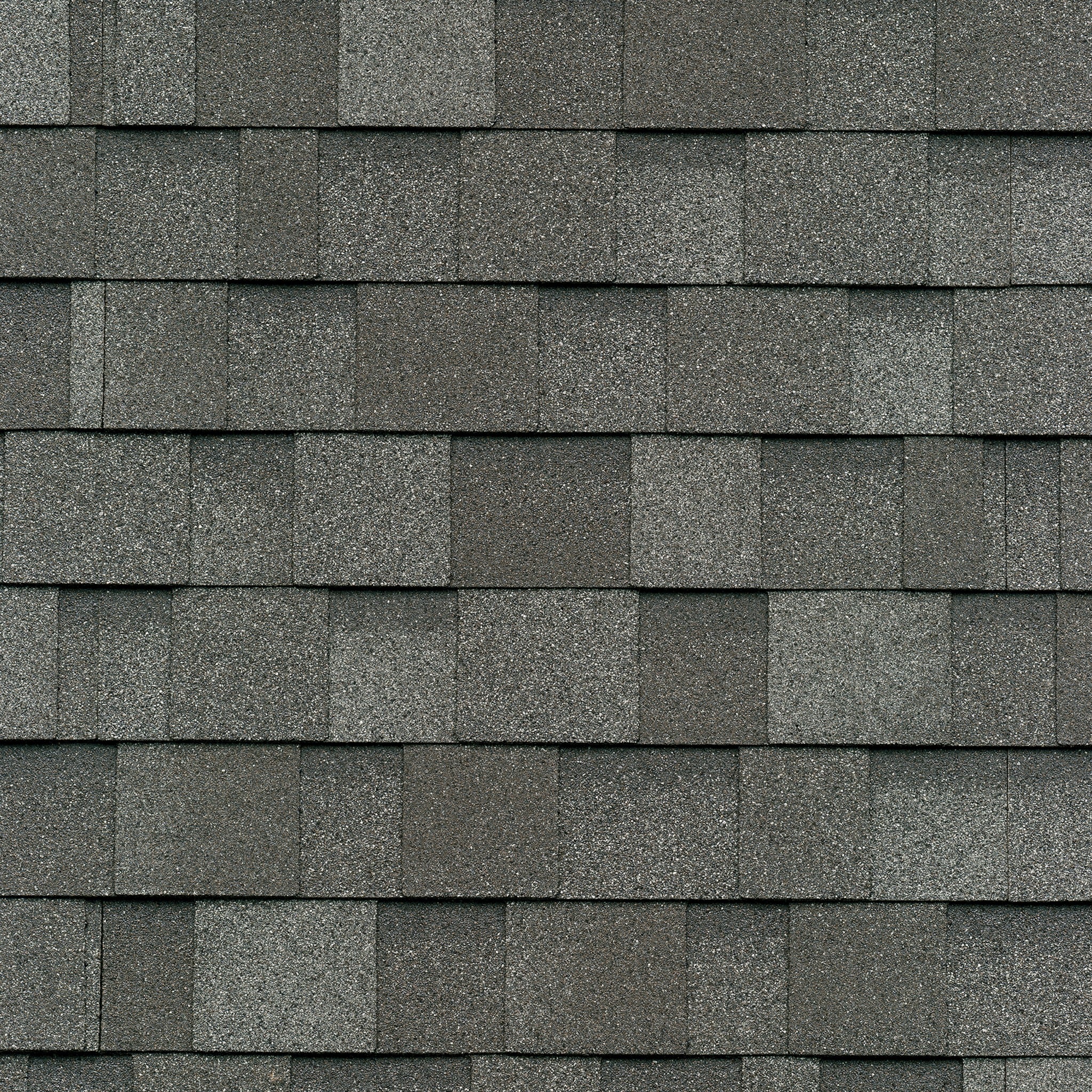 Close-up view of overlapping gray asphalt shingles, resembling the Harvard Slate, forming a regular pattern with cool colors, used as roofing material.